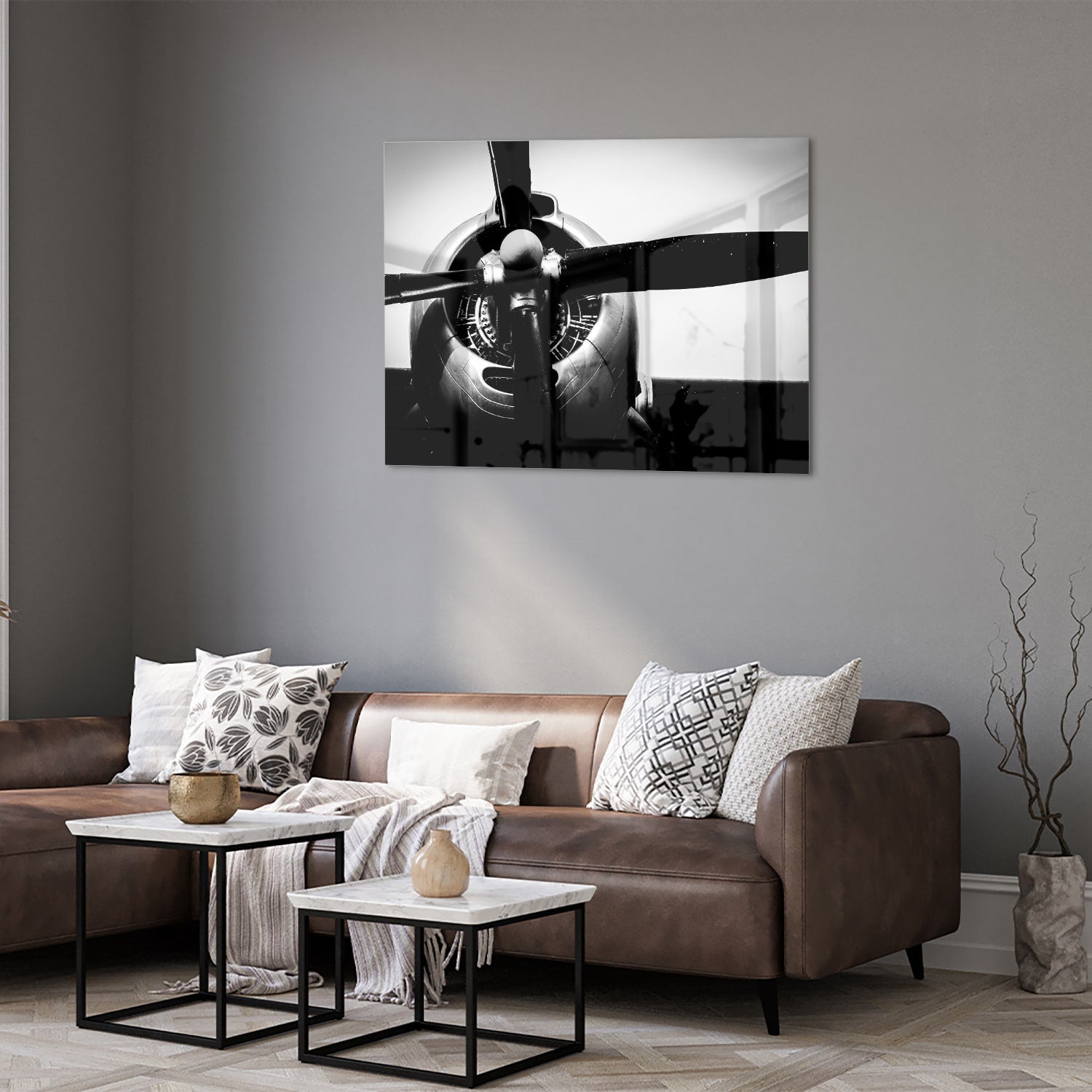 Zwart-wit glazen schilderij van een vintage vliegtuigpropeller tegen een lichte muur.