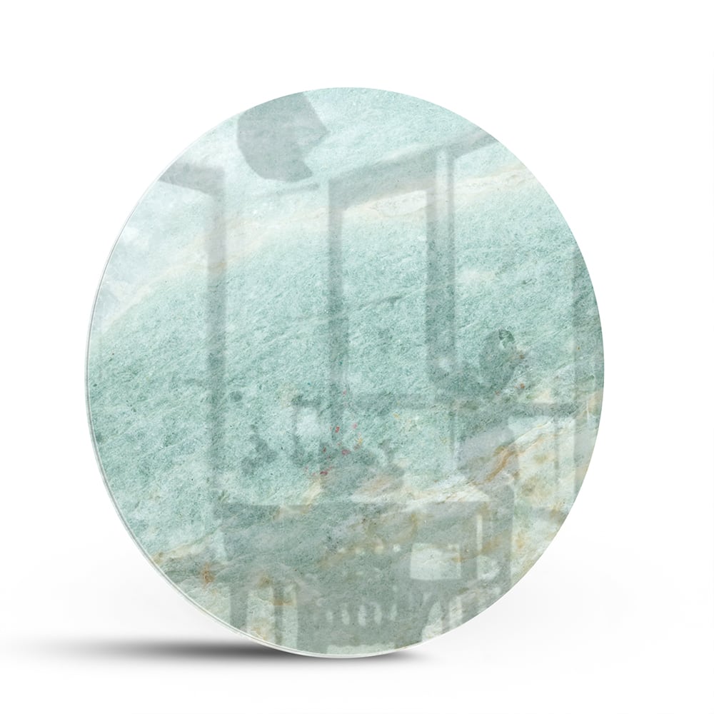 Abstract glazen schilderij in groentinten aan de muur in een moderne woonkamer.