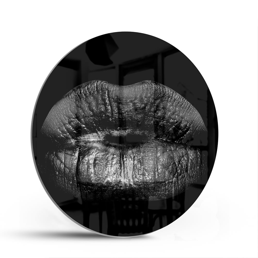 Zwart glazen schilderij met een artistieke lippenprint aan de muur.
