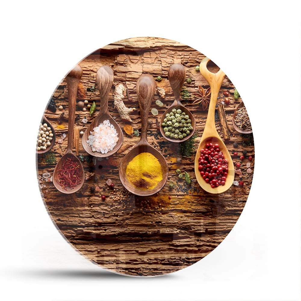 Glazen schilderij met kleurrijke specerijen en houten lepels op een rustieke achtergrond.