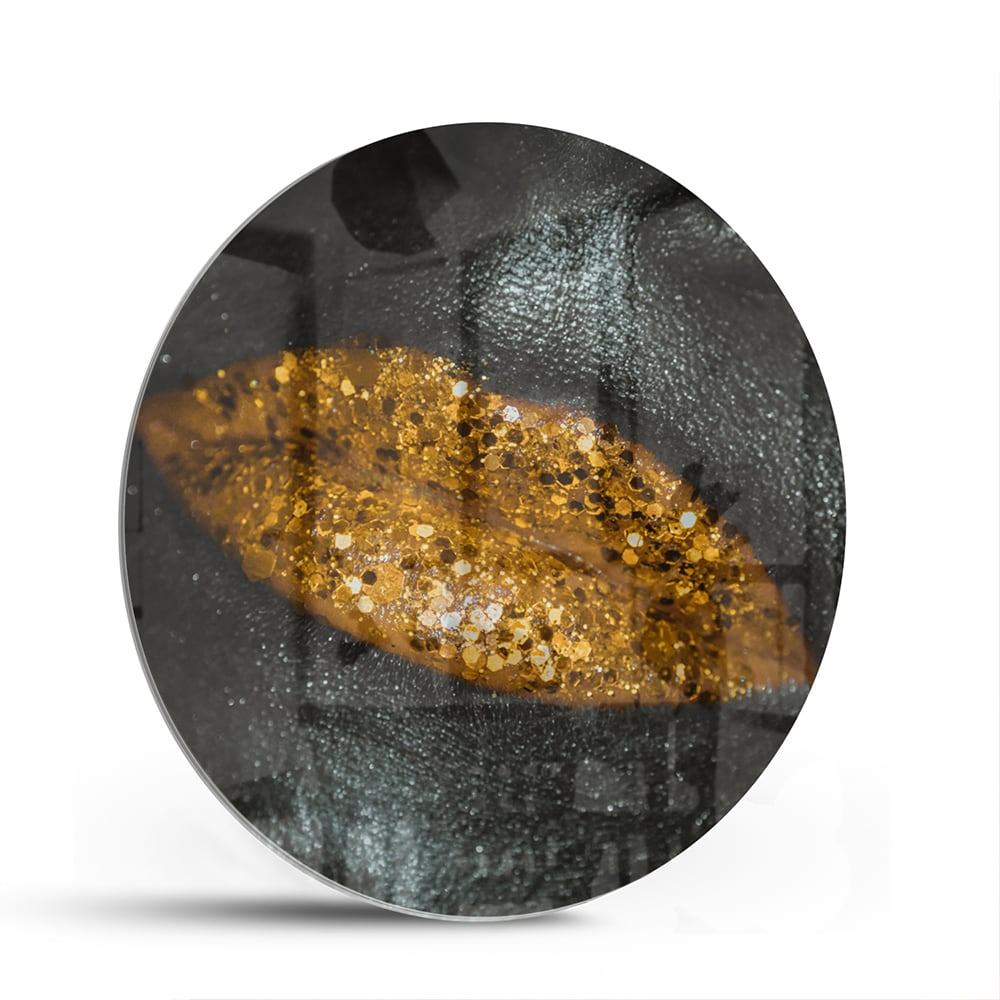 Glazen schilderij met een gouden blad op een zwarte achtergrond, perfect voor moderne interieurs.
