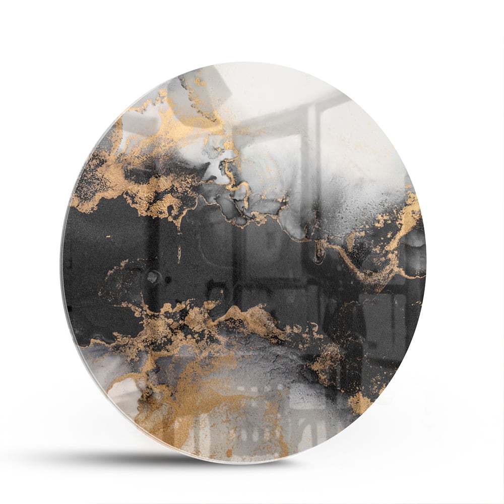 Glazen schilderij met zwarte en gouden abstracte patronen aan de muur boven een houten kast.