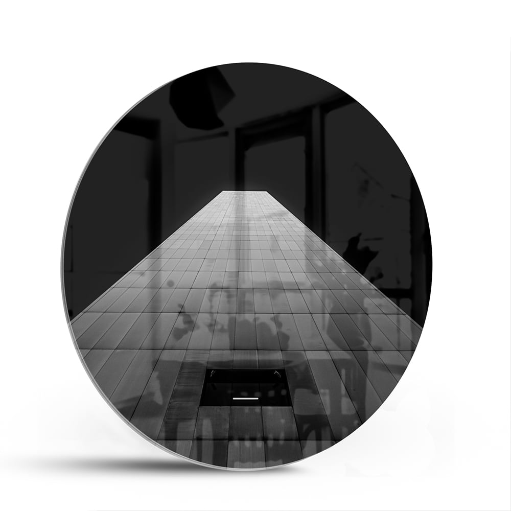 Minimalistisch glazen schilderij met lichtinval op houten vloer