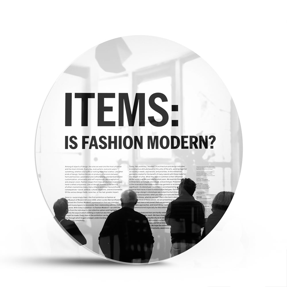 Glazen schilderij met de tekst 'ITEMS: IS FASHION MODERN?', stijlvol gepresenteerd boven een houten meubel.