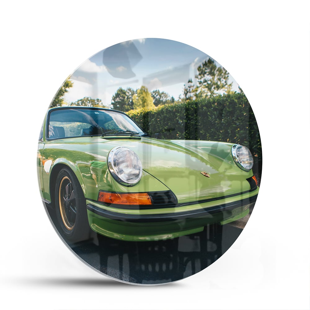 Glas schilderij van een groene Porsche aan de muur in een stijlvol interieur