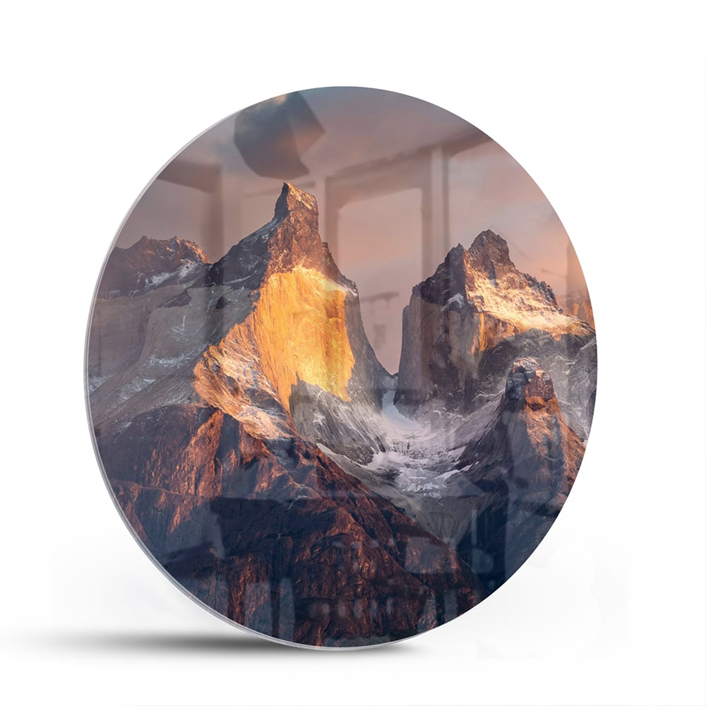 Glazen schilderij met berglandschap aan de muur in een moderne woonkamer