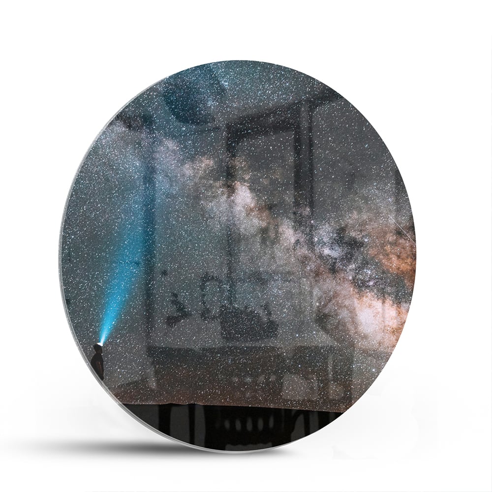 Glazen schilderij van een sterrenhemel met een lichtstraal.