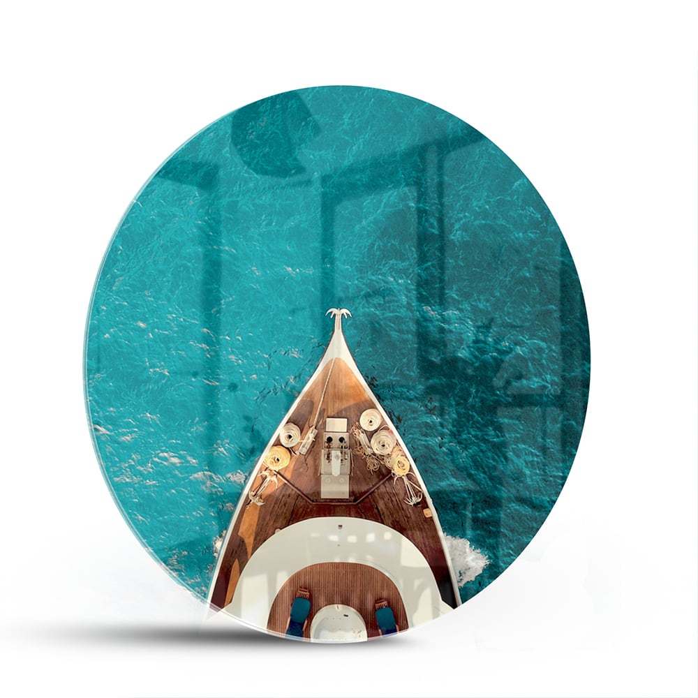 Glazen schilderij van een boot die boven helder turquoise water ligt.