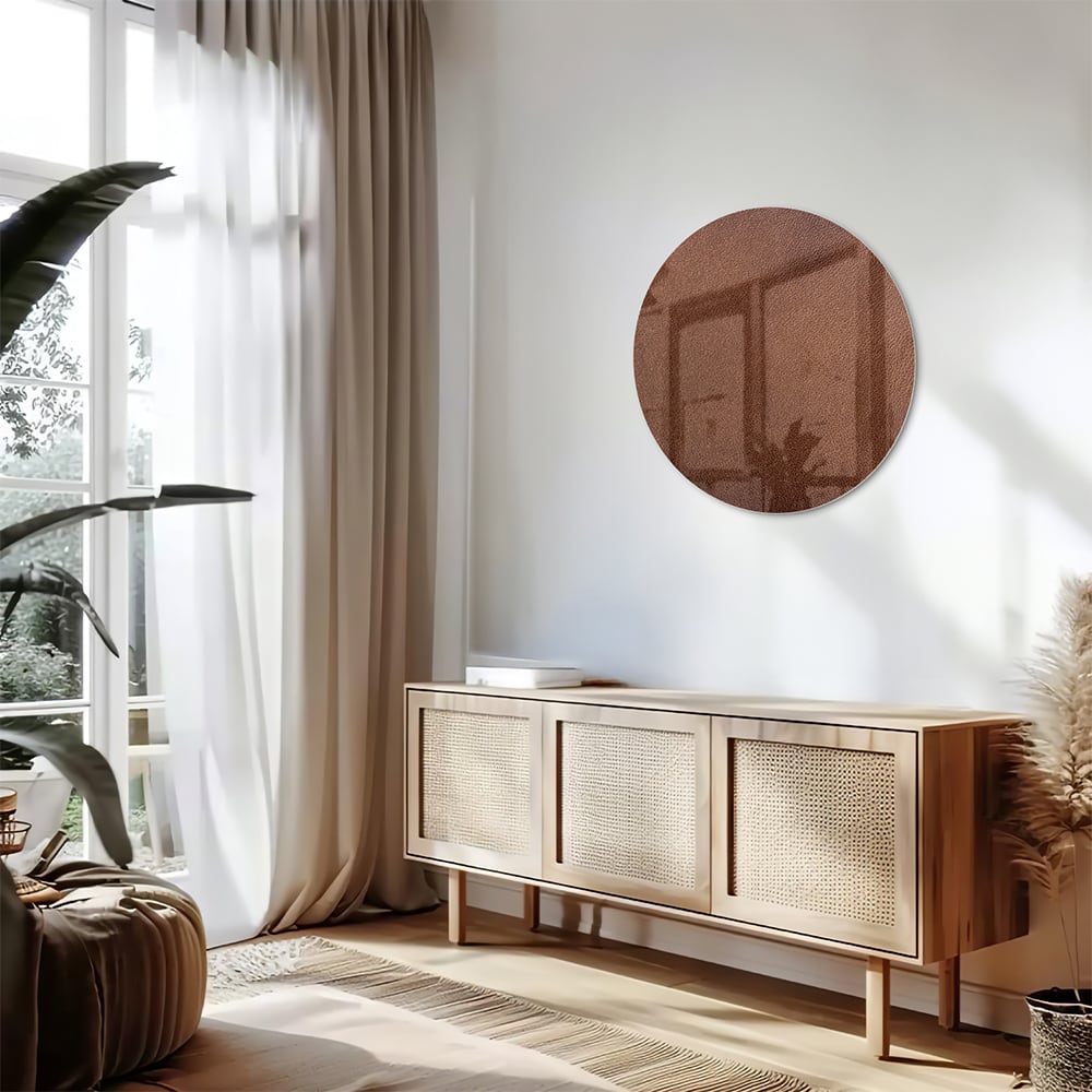 Glazen schilderij in aardetinten, op een witte muur boven een houten meubel.