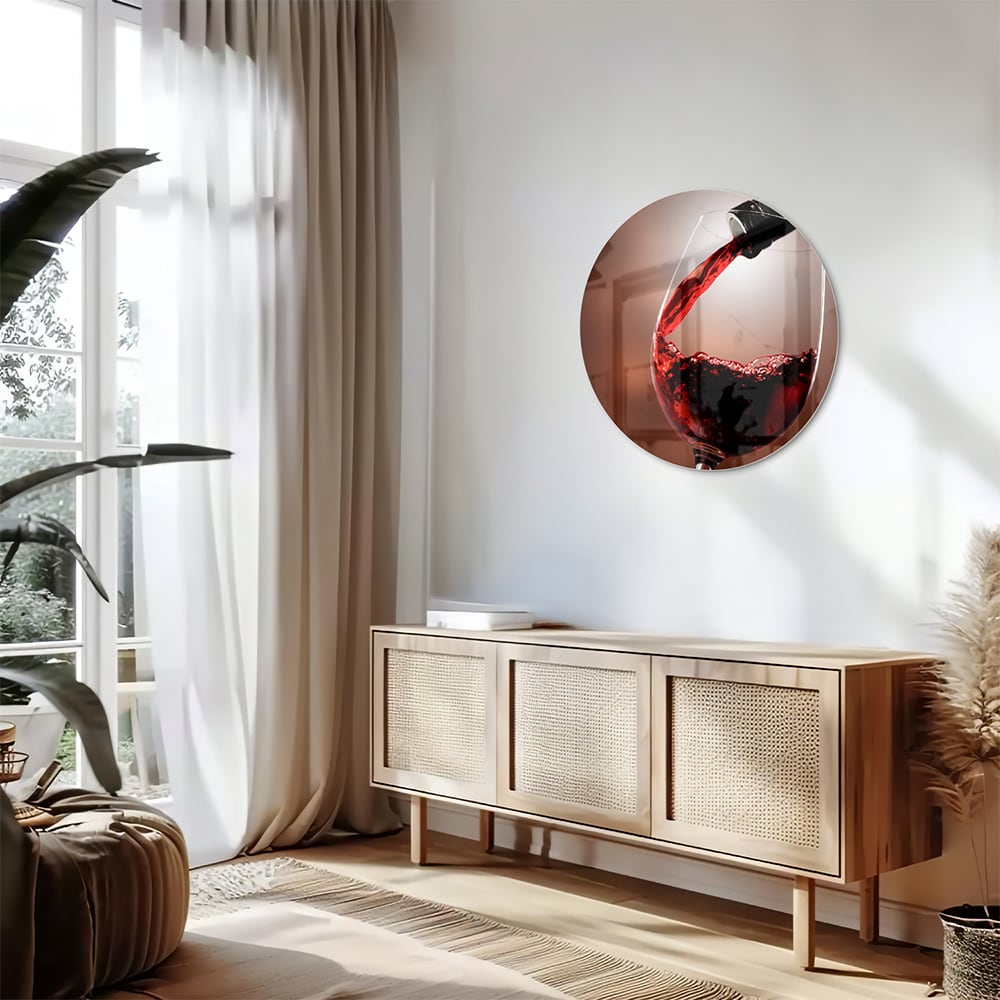 Glazen schilderij van een rode wijn die in een glas wordt ingeschonken, zichtbaar in een moderne woonkamer.