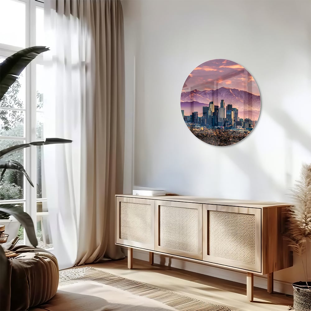 Glazen schilderij van een stadspanorama bij zonsondergang met bergen op de achtergrond.