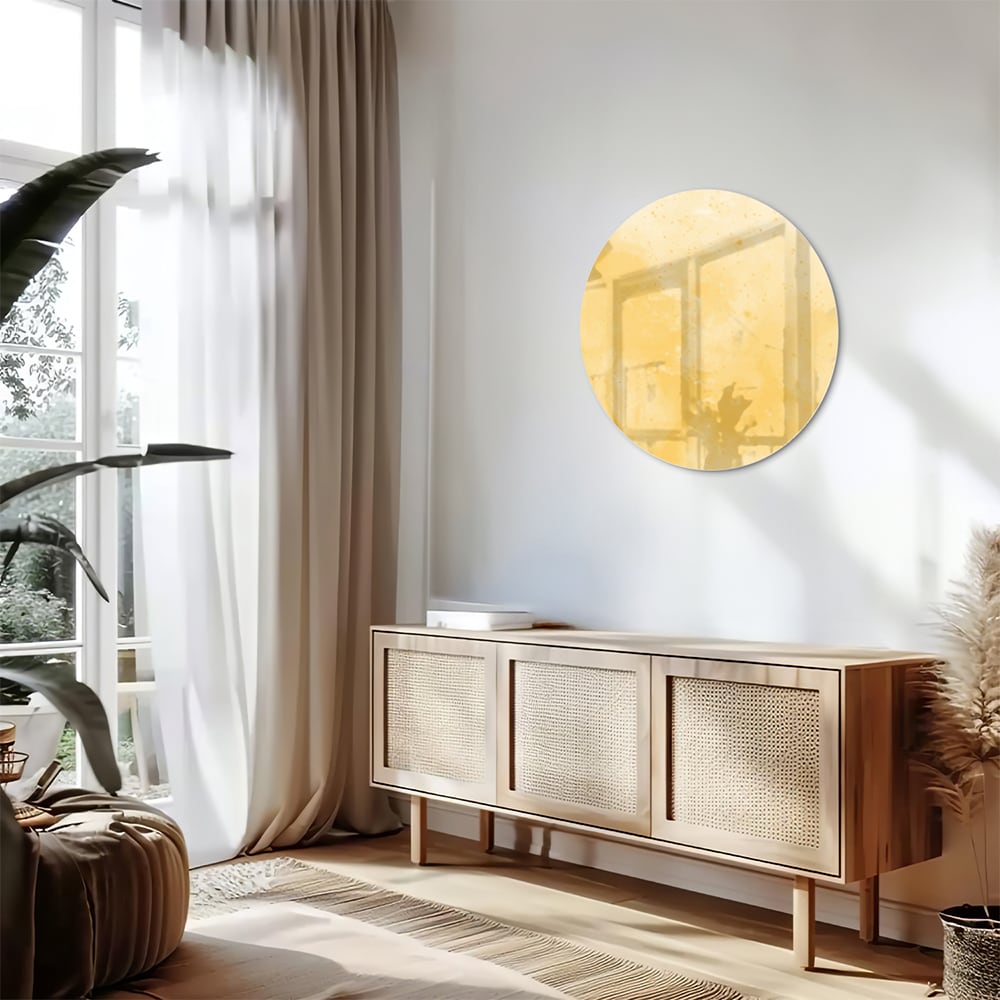 Abstract glazen schilderij in gouden tinten op een witte muur in een moderne woonkamer.