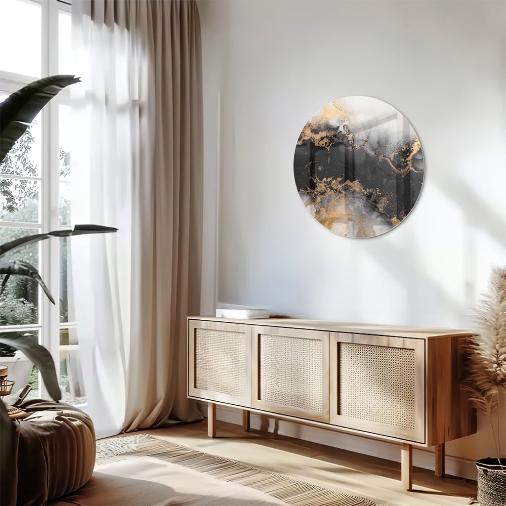 Glazen schilderij met zwarte en gouden abstracte patronen aan de muur boven een houten kast.