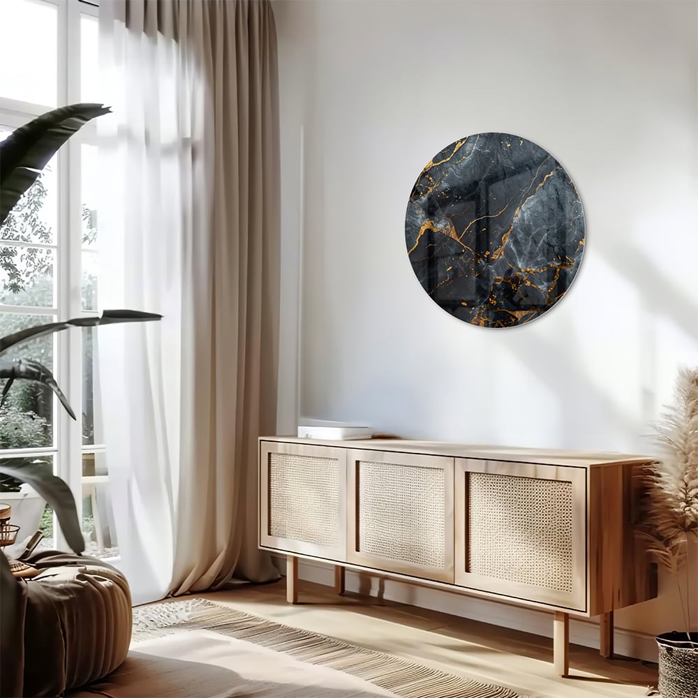 Glazen schilderij met marmerlook in zwart met gouden details aan de muur.