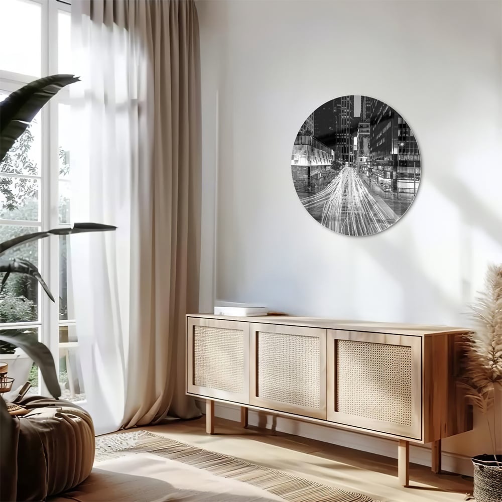 Glazen schilderij met stadslichten in zwart-wit boven een moderne meubelset.