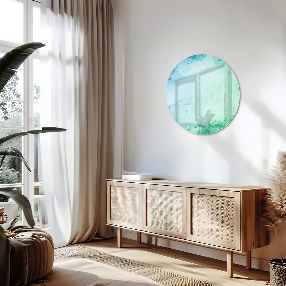 Abstract glazen schilderij in diverse tinten blauw en groen aan de muur.