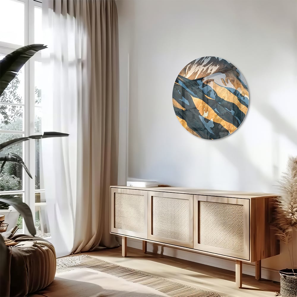 Glazen schilderij van bergen in blauw en goud, hanging in een stijlvolle kamer.