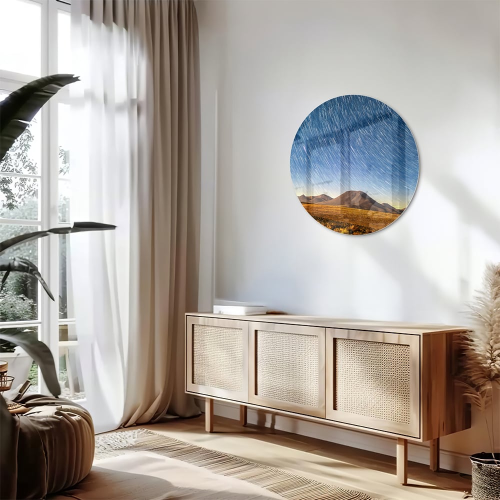 Glazen schilderij met sterrenhemel boven bergen, hangend aan de muur.