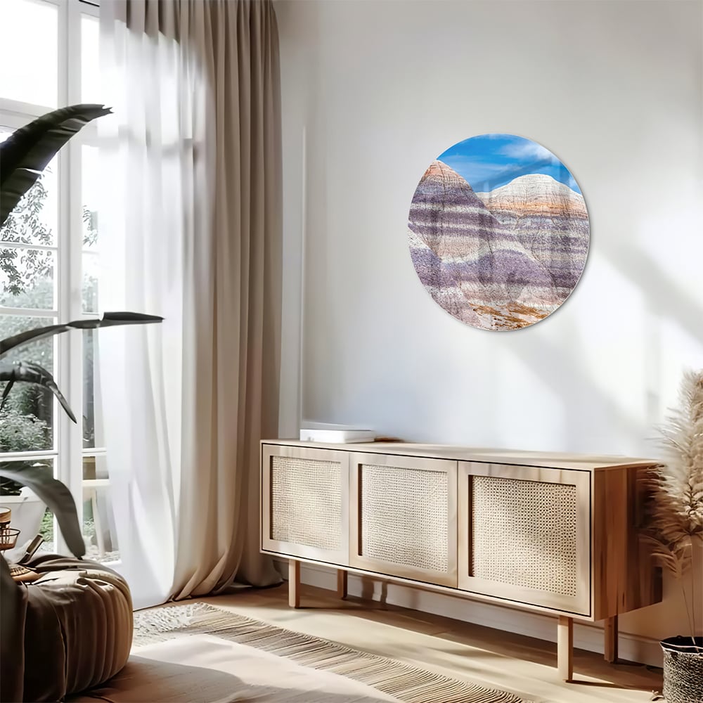 Glazen schilderij van bergen met een blauwe lucht in een moderne woonkamer.