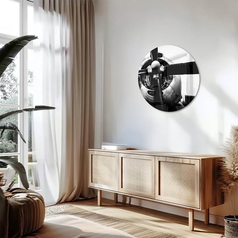 Zwart-wit glazen schilderij van een vintage vliegtuigpropeller tegen een lichte muur.
