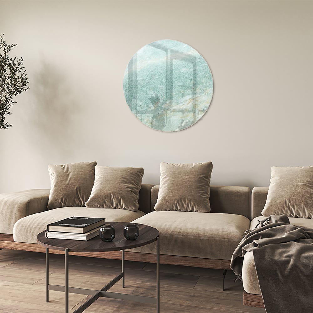 Abstract glazen schilderij in groentinten aan de muur in een moderne woonkamer.