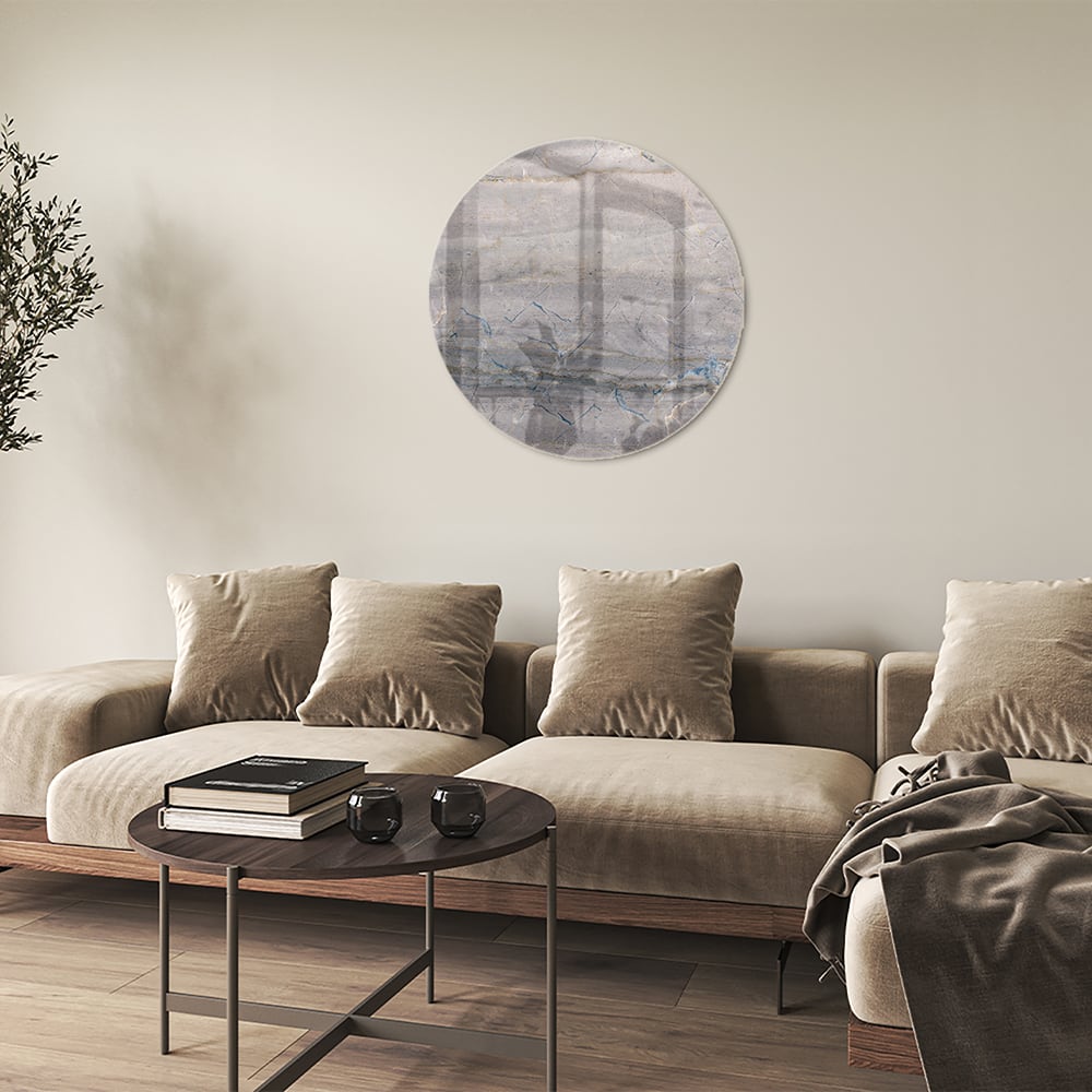 Glazen schilderij in aardetinten hangt aan de muur in een moderne woonkamer.