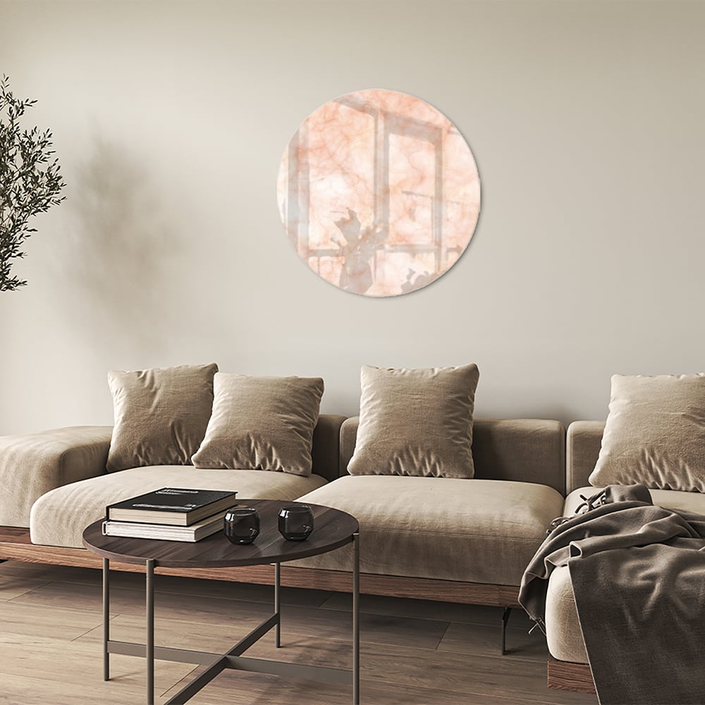 Lichtroze abstract glazen schilderij aan de muur boven een houten kast.