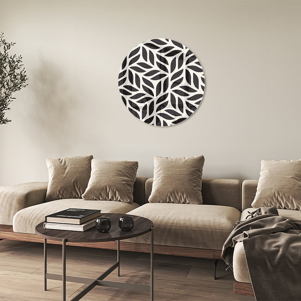 Zwart-wit glazen schilderij met bladerenpatroon aan de muur in een moderne woonkamer.