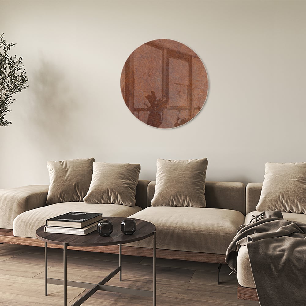 Abstract glazen schilderij met aardetinten boven een houten meubel.