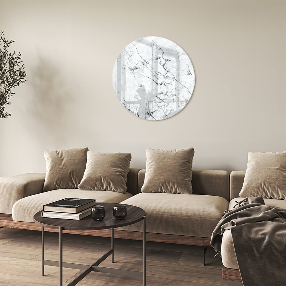 Glazen schilderij met marmerlook aan de muur in een moderne woonkamer.