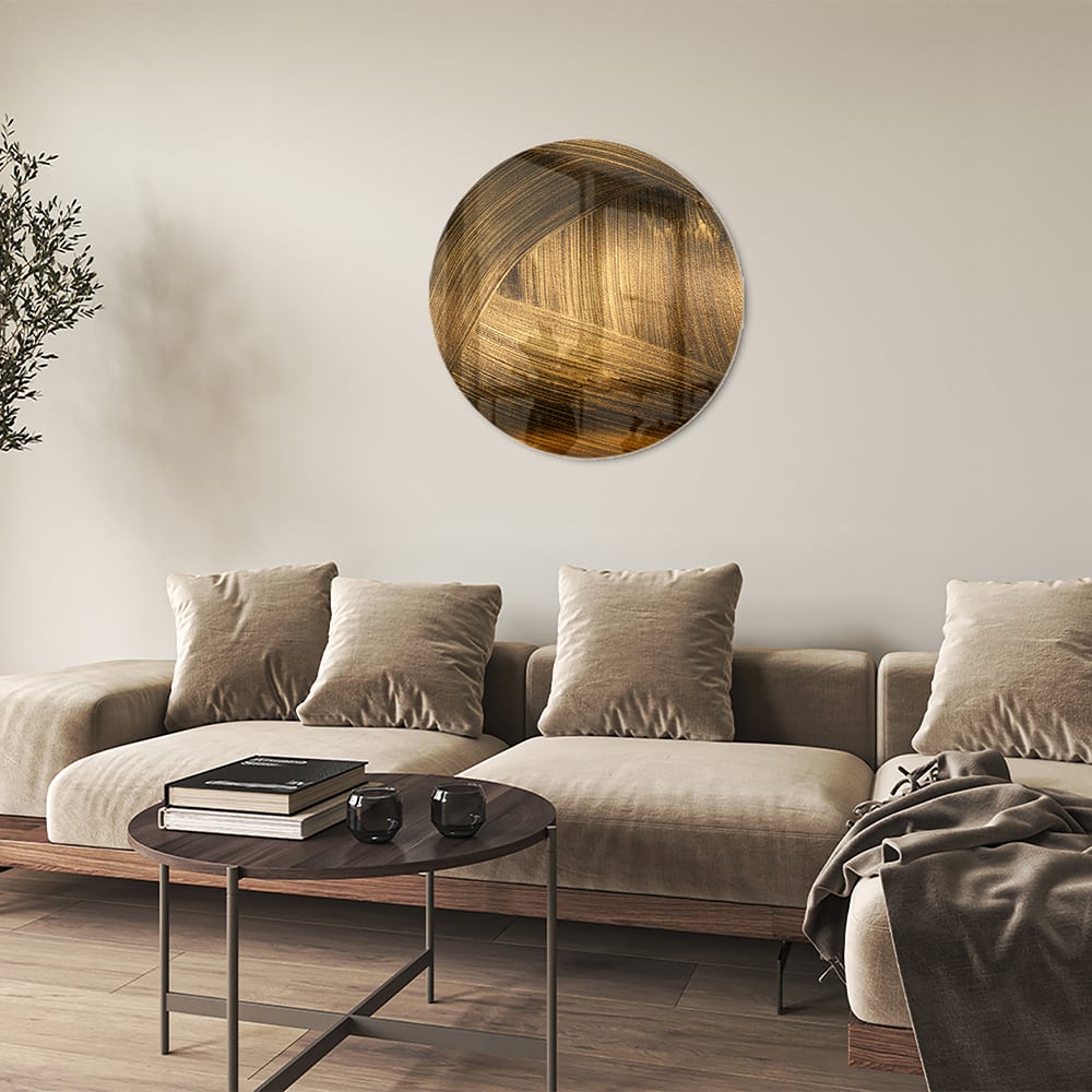 Glazen schilderij met gouden patronen aan de muur boven een houten meubel.