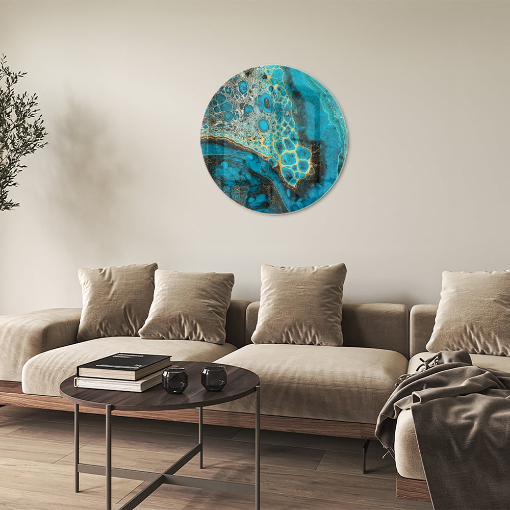 Glazen schilderij in turkoois met gouden accenten aan de muur boven een houten meubel.