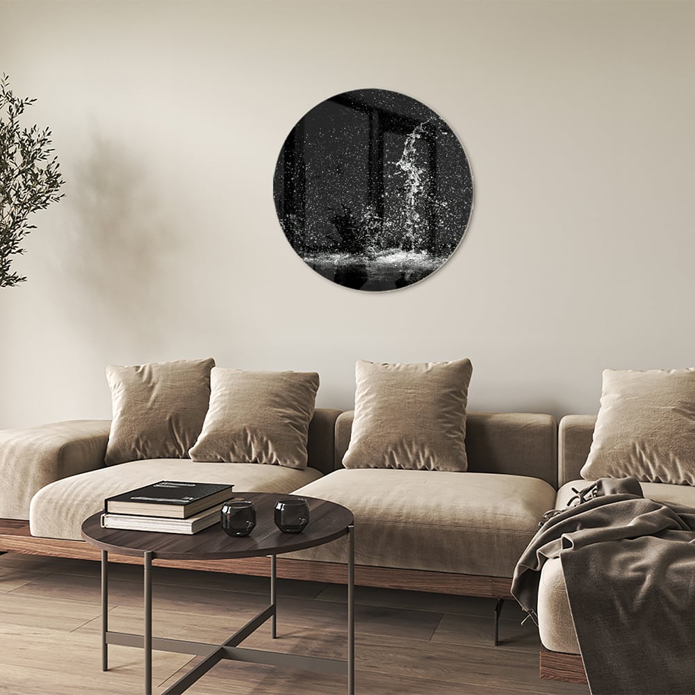 Zwart-wit glazen schilderij met een dynamisch spatwatereffect aan de muur.