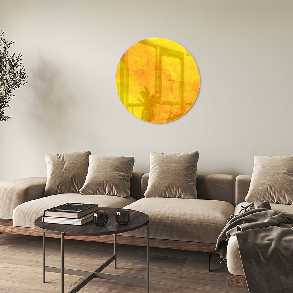 Gele glazen schilderij boven een houten bureau in een woonkamer.