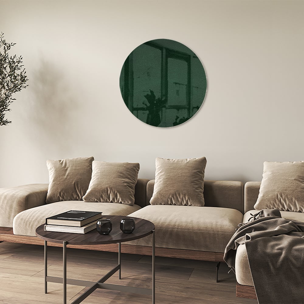 Een groen glazen schilderij aan de muur in een lichte woonkamer