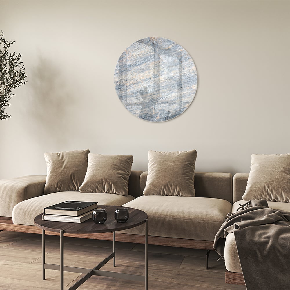 Abstract glazen schilderij met blauwe en oranje tinten aan de muur in een moderne woonkamer.