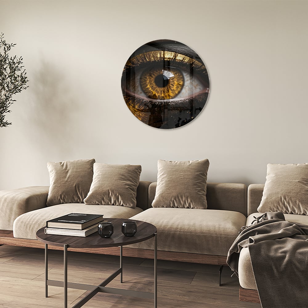 Glazen schilderij van een gouden oog op een zwarte achtergrond, hangt aan de muur.