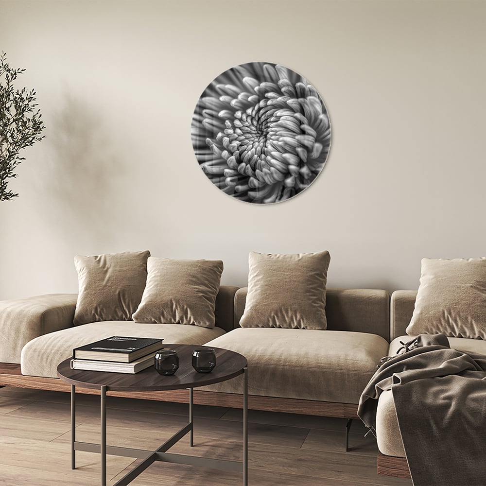 Zwart-wit glas schilderij van een kronkelige bloem aan de muur.