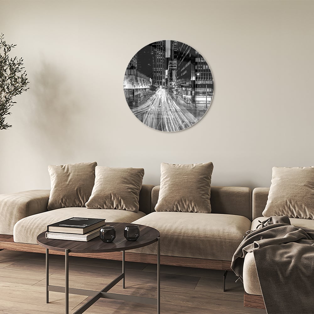 Glazen schilderij met stadslichten in zwart-wit boven een moderne meubelset.
