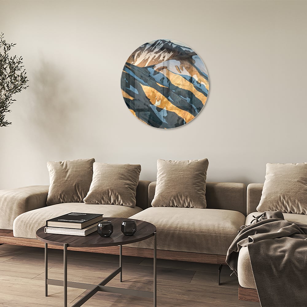 Glazen schilderij van bergen in blauw en goud, hanging in een stijlvolle kamer.