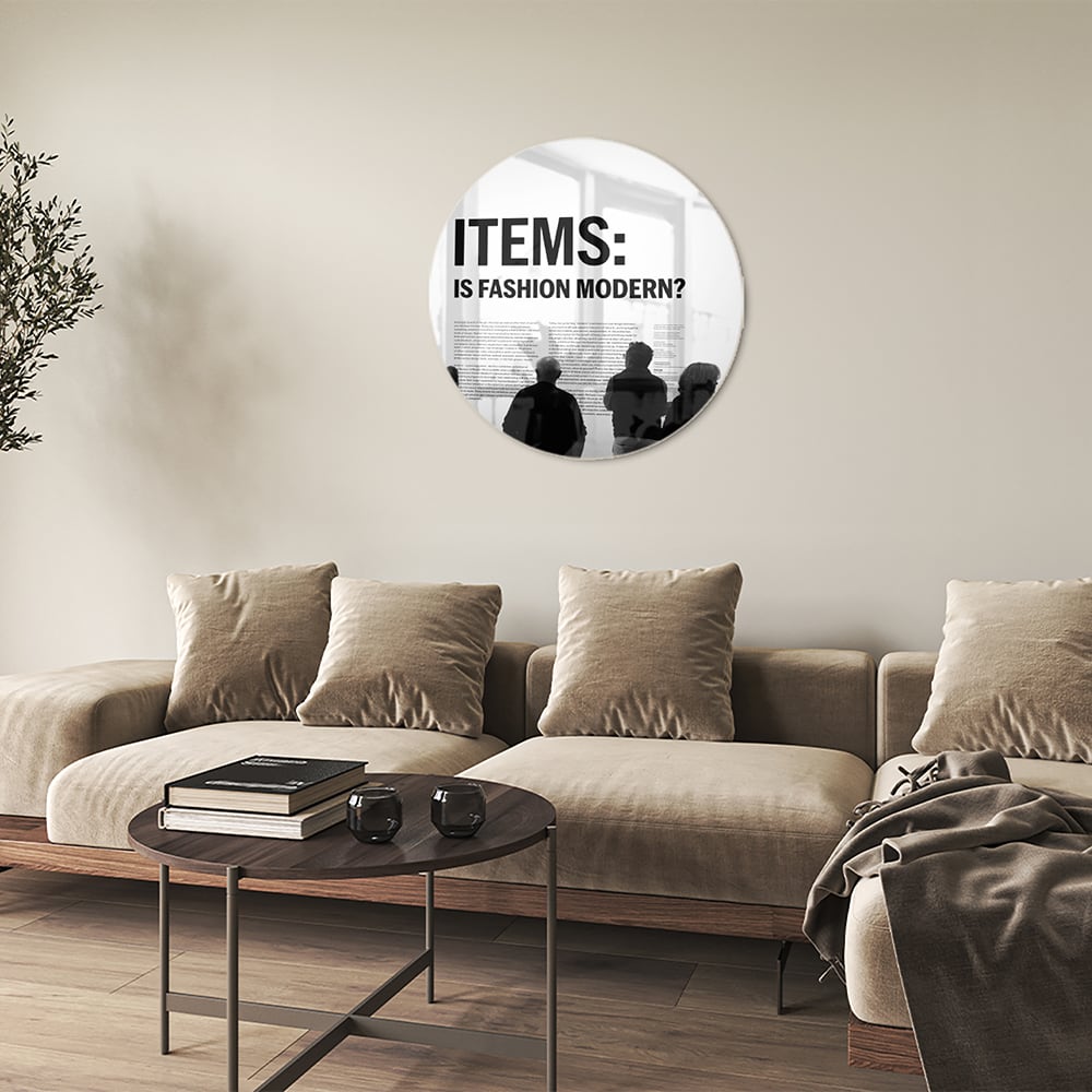 Glazen schilderij met de tekst 'ITEMS: IS FASHION MODERN?', stijlvol gepresenteerd boven een houten meubel.