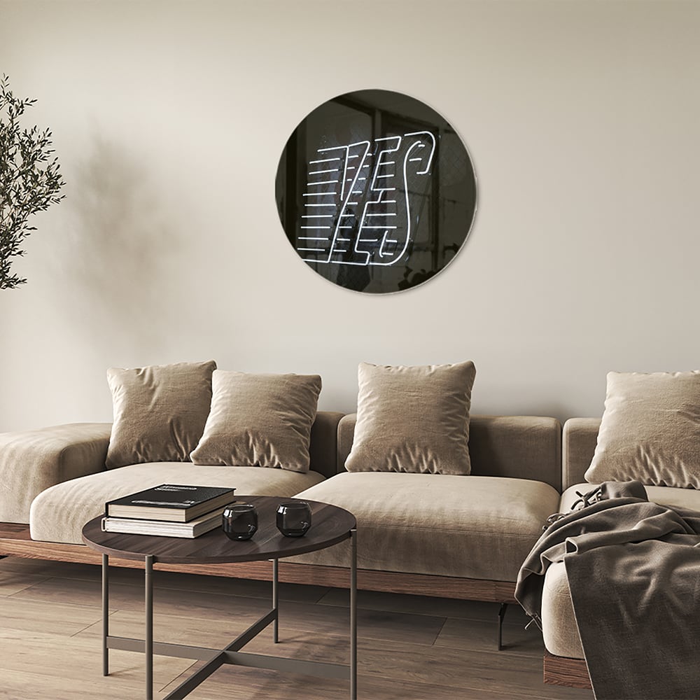 Glazen schilderij met 'YES' text in zwart en wit, hangend aan de muur.