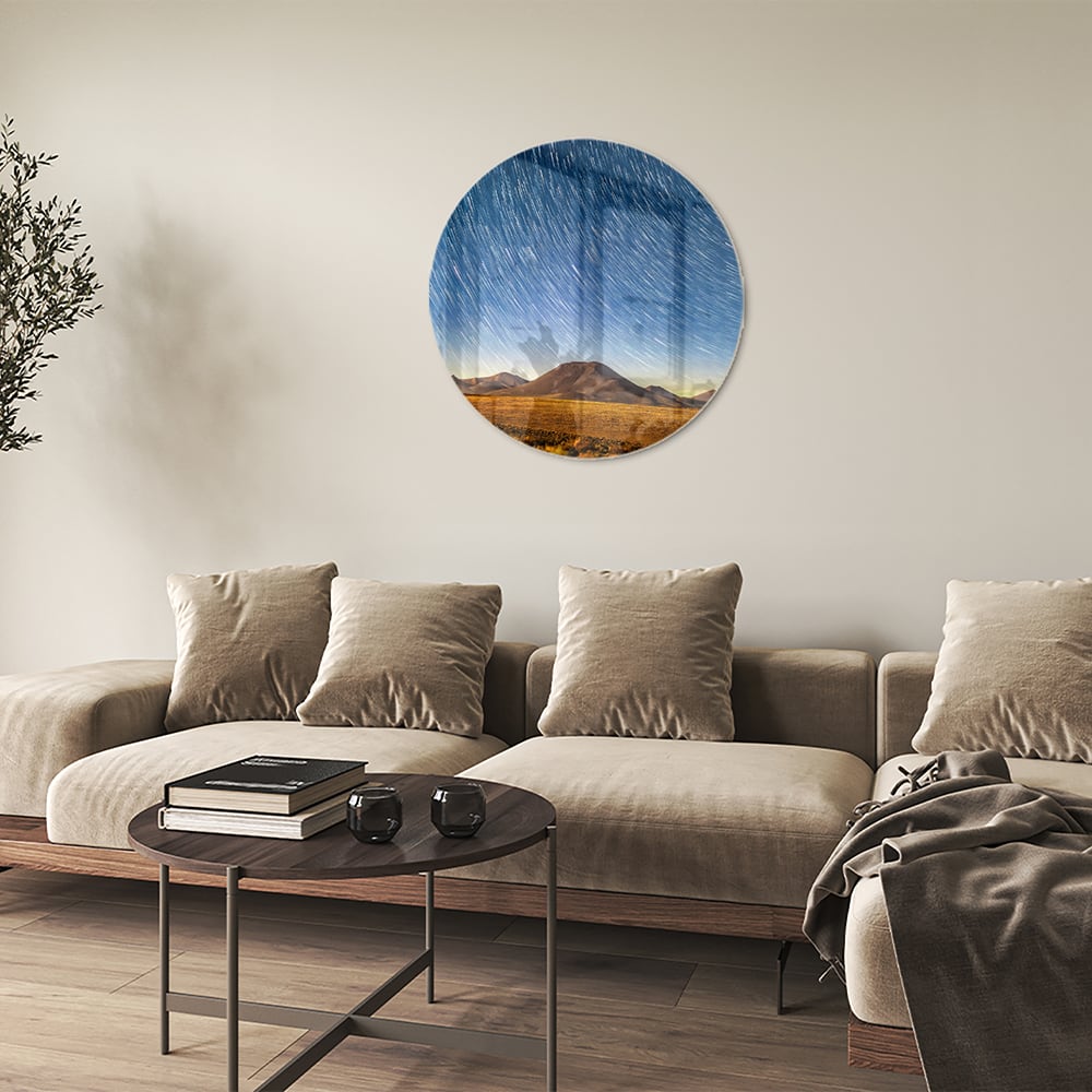 Glazen schilderij met sterrenhemel boven bergen, hangend aan de muur.