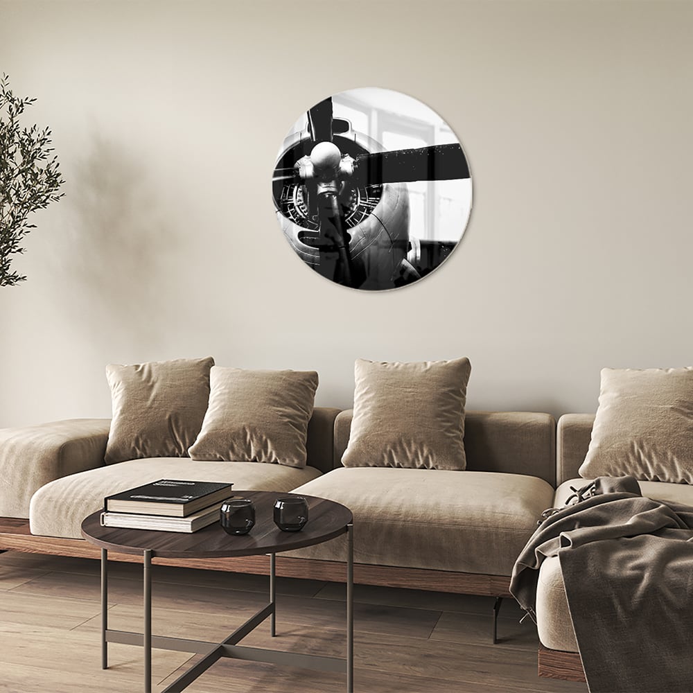 Zwart-wit glazen schilderij van een vintage vliegtuigpropeller tegen een lichte muur.