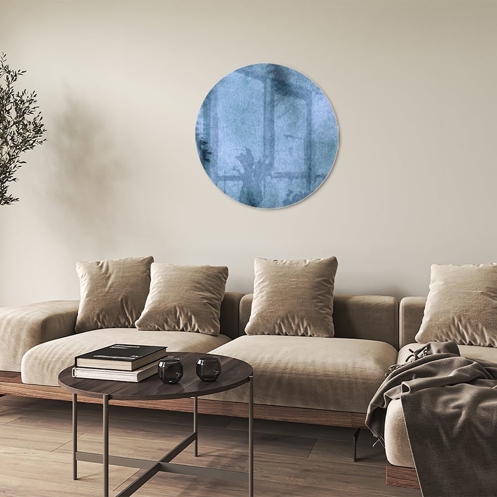 Blauw glazen schilderij aan de muur boven een houten kast in een elegant interieur.