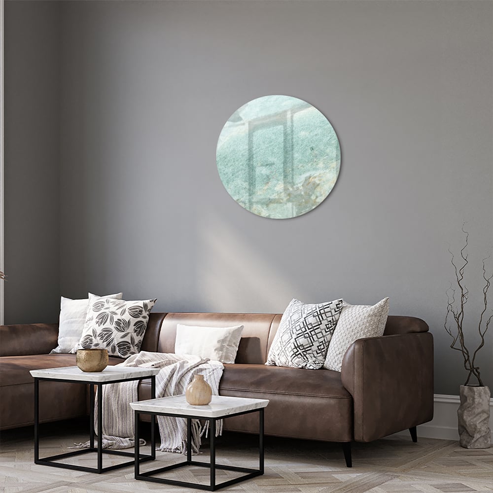 Abstract glazen schilderij in groentinten aan de muur in een moderne woonkamer.