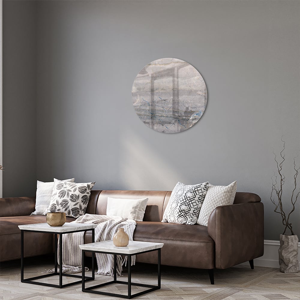Glazen schilderij in aardetinten hangt aan de muur in een moderne woonkamer.