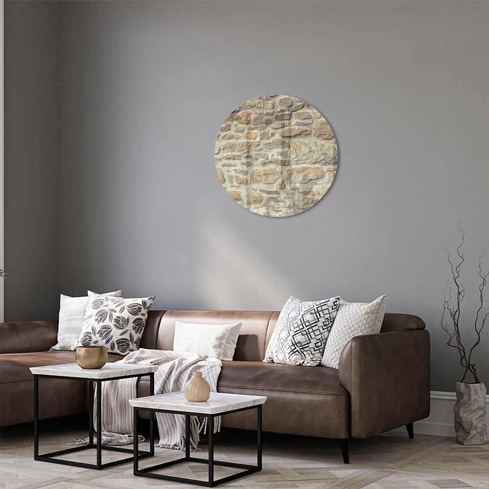 Glazen schilderij van een rustieke stenen muur in een lichte woonkamer.