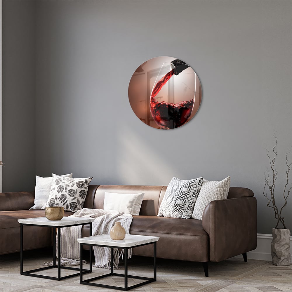 Glazen schilderij van een rode wijn die in een glas wordt ingeschonken, zichtbaar in een moderne woonkamer.