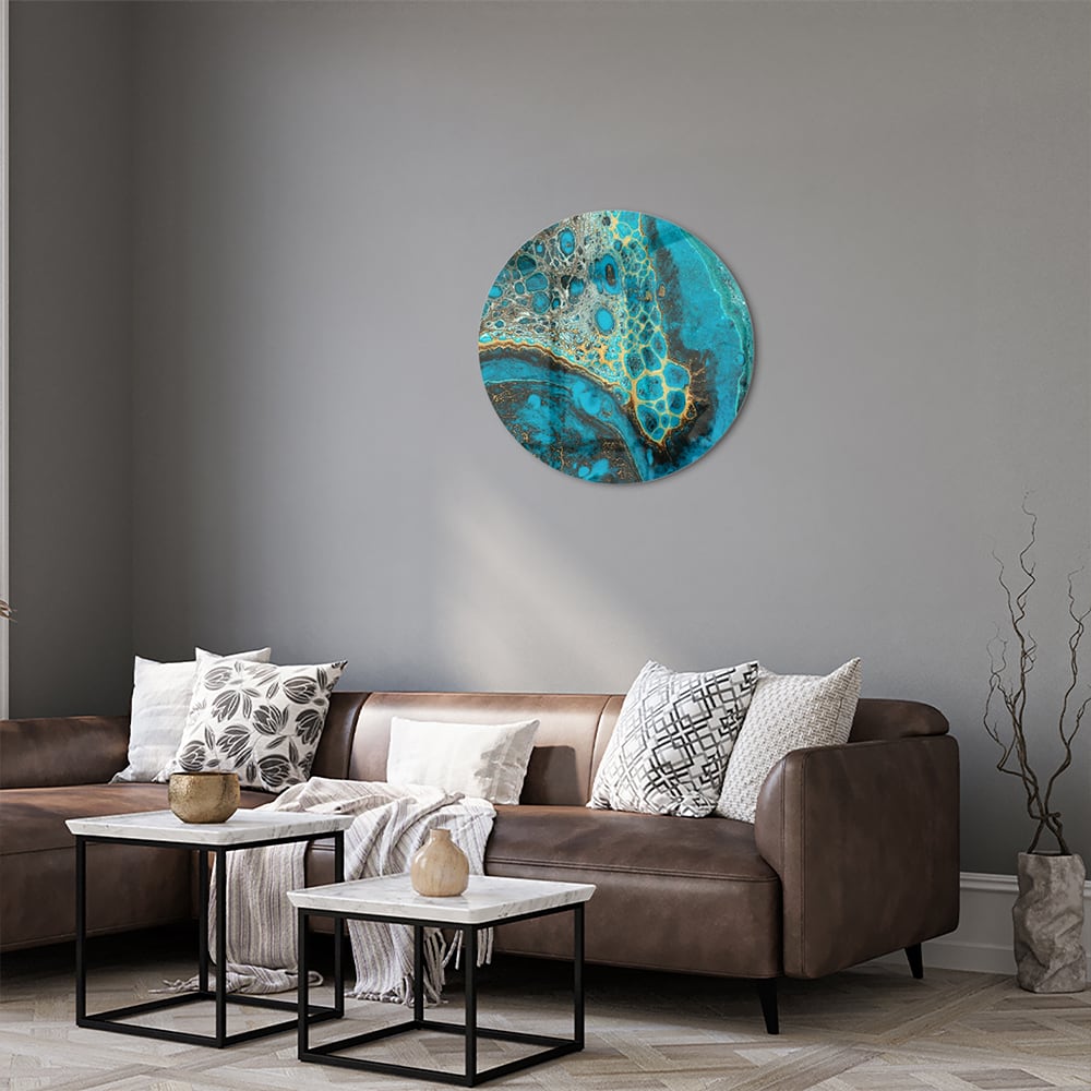 Glazen schilderij in turkoois met gouden accenten aan de muur boven een houten meubel.